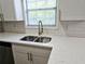 Kitchen sink with stainless fixtures set in white quartz countertop and subway tile backsplash at 4093 Chapel Mill Bnd, Decatur, GA 30034
