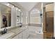 Bright bathroom features a soaking tub, walk-in shower, granite counters and large windows at 5960 Sarah Orr Ln, Cumming, GA 30040