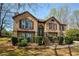 Beautiful brick home with stone accents, manicured bushes, and a stairway to the front door at 5960 Sarah Orr Ln, Cumming, GA 30040
