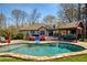 Inviting backyard pool area with a covered lounge, hot tub, and manicured lawn at 5960 Sarah Orr Ln, Cumming, GA 30040