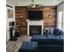Cozy living room with hardwood floors, wooden accent wall, fireplace, and comfortable seating, great for relaxation at 1503 Korona Ct, Woodstock, GA 30188