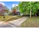 Charming home with a covered porch, long driveway, mature trees, and landscaping at 2425 Shiloh Sw Dr, Marietta, GA 30064