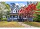 Beautiful two-story home with front porch, colorful tree, and landscaped front yard at 2425 Shiloh Sw Dr, Marietta, GA 30064