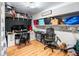Home office space featuring wood floors, computer setup, overhead lighting, and ample shelving storage at 2425 Shiloh Sw Dr, Marietta, GA 30064