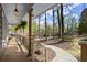 Relaxing covered porch with stone flooring, decorative light fixtures, and scenic views of the tree-lined neighborhood at 250 Martin Ridge Ct, Roswell, GA 30076