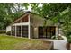 Home exterior featuring a screened-in porch, modern windows, manicured lawn, and lush greenery at 3063 Leafwood Dr, Decatur, GA 30033
