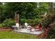 Patio with a seating area and grill perfect for outdoor entertaining surrounded by lush greenery at 3063 Leafwood Dr, Decatur, GA 30033