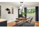 This dining room features a rustic wooden table, dark rug, large window and modern pendant lighting at 3063 Leafwood Dr, Decatur, GA 30033