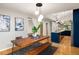 This dining room features a rustic wooden table, dark rug, and is adjacent to the modern kitchen at 3063 Leafwood Dr, Decatur, GA 30033