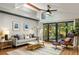Open living room with vaulted ceilings, hardwood floors, and large sliding doors leading to a screened-in porch overlooking the yard at 3063 Leafwood Dr, Decatur, GA 30033