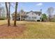 Spacious backyard view featuring a white home with a covered patio and manicured lawn at 3642 Falls Trl, Winston, GA 30187