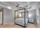 A bright bedroom with a four-poster bed, tray ceilings, and neutral walls at 3642 Falls Trl, Winston, GA 30187