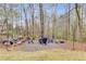 Secluded backyard firepit area with seating, surrounded by trees for privacy at 3642 Falls Trl, Winston, GA 30187