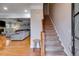 Inviting living room featuring hardwood floors, a cozy fireplace, and an adjacent staircase to the upper level at 3642 Falls Trl, Winston, GA 30187
