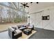 Inviting covered patio with sectional seating, dart board, and views of the serene wooded backyard at 3642 Falls Trl, Winston, GA 30187