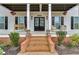Inviting front porch with double doors, a sitting bench, and black shuttered windows at 3642 Falls Trl, Winston, GA 30187