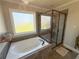 Luxurious bathroom featuring a soaking tub, glass-enclosed shower, and natural light at 273 Crowe Springs Nw Rd, Cartersville, GA 30121