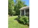 View of a green backyard with lush landscaping, mature trees, and relaxing hot tub at 3455 Buffington Ln, Cumming, GA 30040