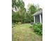 Manicured backyard with mature trees, green lawn, hot tub in rear at 3455 Buffington Ln, Cumming, GA 30040