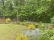 Lush backyard featuring a variety of plants, flowers, and a peaceful wooded area at 3455 Buffington Ln, Cumming, GA 30040