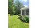 Expansive backyard with well-kept lawn, a screened-in porch, and vibrant flowering bushes at 3455 Buffington Ln, Cumming, GA 30040