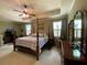 Spacious main bedroom with a four-poster bed, ceiling fan, and natural light at 3455 Buffington Ln, Cumming, GA 30040