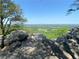 Picturesque view of vast green fields and distant mountains framed by scenic rock formations at 3455 Buffington Ln, Cumming, GA 30040