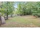 Large backyard featuring a white fence, mature trees, and well-maintained grass at 995 Litchfield Pl, Roswell, GA 30076
