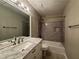 Cozy bathroom featuring a shower-tub combo, vanity mirror, and ceramic tile at 995 Litchfield Pl, Roswell, GA 30076