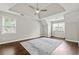 Spacious primary bedroom featuring a tray ceiling, ceiling fan, hardwood floors and lots of natural light at 995 Litchfield Pl, Roswell, GA 30076