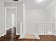 Upstairs hallway features wood floors and a view of the home's staircase at 995 Litchfield Pl, Roswell, GA 30076