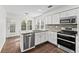 Bright kitchen featuring stainless steel appliances, white cabinets and an island at 995 Litchfield Pl, Roswell, GA 30076