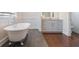 A full view of a clawfoot tub in a bathroom with hardwood and tile flooring at 3080 Dickson Ne St, Brookhaven, GA 30319
