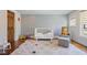 The bedroom features a colorful rug, rocking chair, and crib at 3080 Dickson Ne St, Brookhaven, GA 30319