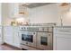 Modern kitchen featuring a large range with double ovens, stainless steel hood, and white cabinetry at 3080 Dickson Ne St, Brookhaven, GA 30319