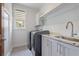 Laundry room with gray cabinets, granite countertops, sink, and window at 3080 Dickson Ne St, Brookhaven, GA 30319