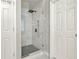 Modern glass enclosed shower with tiled walls and floor in a brightly lit bathroom at 6675 Flagstone Ct, Cumming, GA 30028