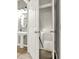 A charming bathroom, with a pedestal sink, decorative mirror, and a view into a storage area at 6675 Flagstone Ct, Cumming, GA 30028
