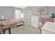 Bright bedroom with a white framed bed, neutral walls, ample natural light, and playful decor at 6675 Flagstone Ct, Cumming, GA 30028
