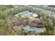Aerial of the community amenities including tennis courts, pool, clubhouse, and wooded pond at 6675 Flagstone Ct, Cumming, GA 30028