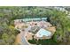 Aerial view of community pool, clubhouse and tennis courts nestled in a wooded area; ideal for active residents at 6675 Flagstone Ct, Cumming, GA 30028