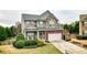 Charming two-story home features a stone and brick facade, two-car garage and welcoming front yard at 6675 Flagstone Ct, Cumming, GA 30028
