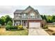 Beautiful two-story home with a stone and brick facade and a well-manicured front yard at 6675 Flagstone Ct, Cumming, GA 30028