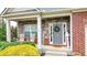 Inviting front porch with stone accents, rocking chairs, and a charming welcome sign by the front door at 6675 Flagstone Ct, Cumming, GA 30028