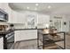 Bright kitchen features white cabinets, stainless steel appliances, dark countertops, and kitchen island at 6675 Flagstone Ct, Cumming, GA 30028
