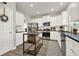 Bright kitchen features white cabinets, stainless steel appliances, dark countertops, and kitchen island at 6675 Flagstone Ct, Cumming, GA 30028