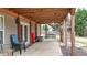 Relaxing covered patio featuring an outdoor swing, string lights, and stairs to the upper deck perfect for entertaining at 6675 Flagstone Ct, Cumming, GA 30028