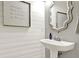 Chic powder room featuring a stylish pedestal sink, shiplap walls, and elegant decor, ideal for guests at 6675 Flagstone Ct, Cumming, GA 30028