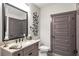 A modern half-bathroom featuring granite counters, an elegant mirror, and stylish accents at 2940 W Village Dr # 60, Suwanee, GA 30024