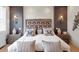 Elegant bedroom with a decorative headboard, stylish lighting, and nightstands at 2940 W Village Dr # 60, Suwanee, GA 30024